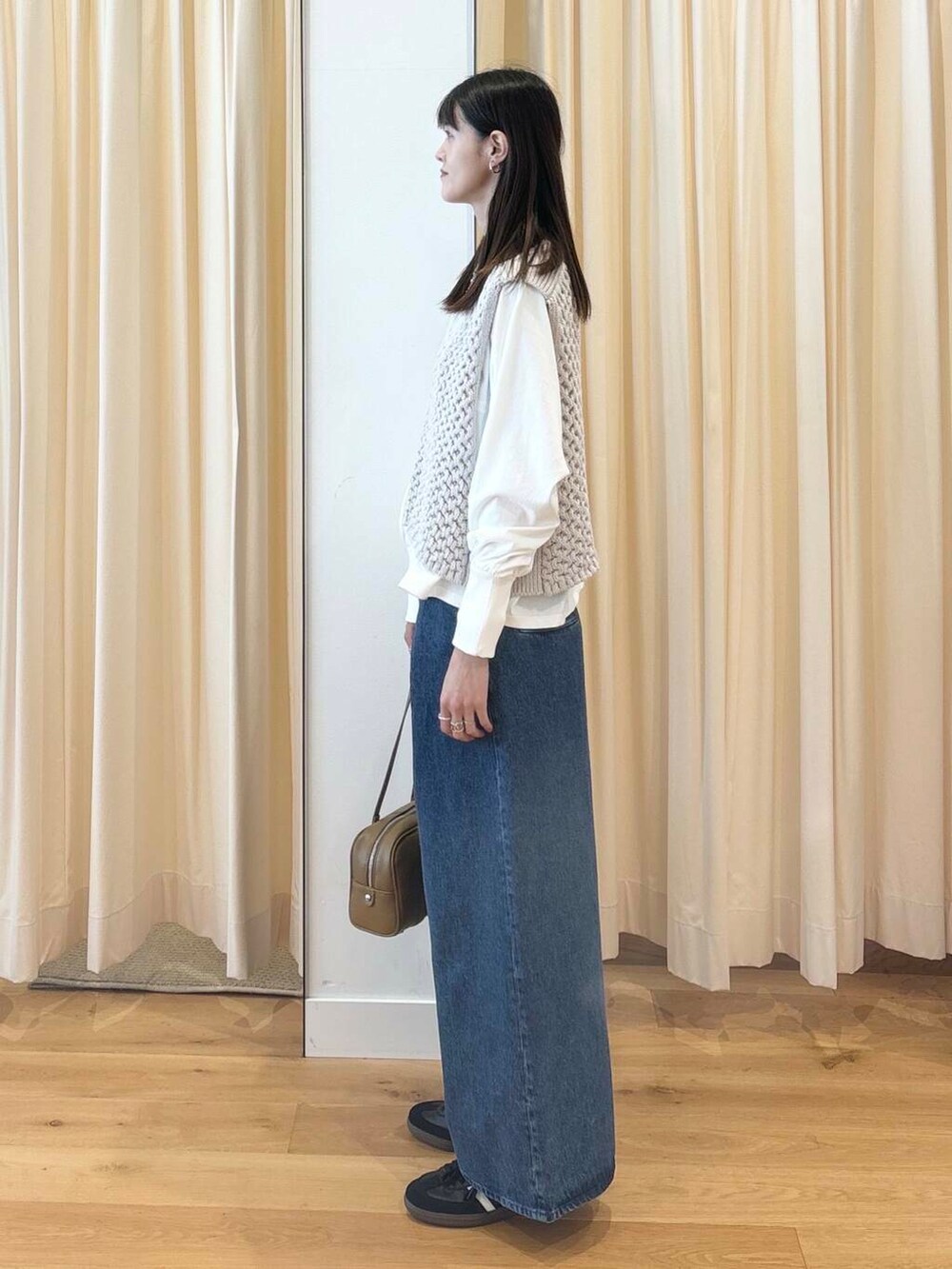 ホワイト系のTシャツ/カットソー、グリーン系のボストンバッグ、ブラック系のスニーカーを着用したレディースの秋コーディネートの3枚目の写真