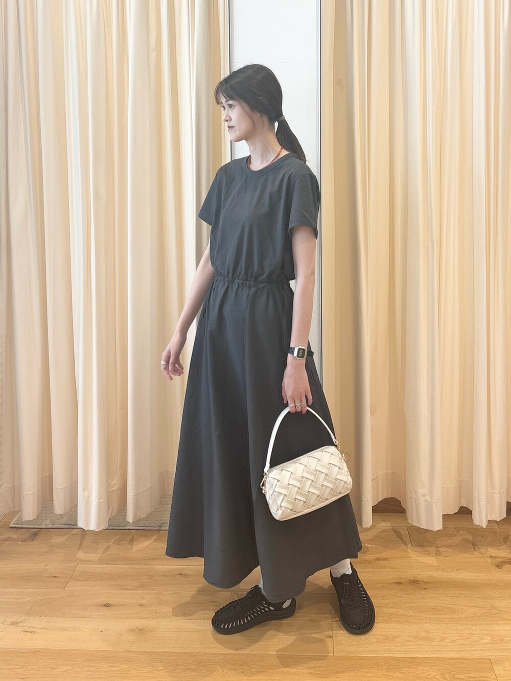 ホワイト系のショルダーバッグ、ブルー系のカーディガン/ボレロ、グレー系のワンピースを着用したレディースの夏コーディネートの2枚目の写真