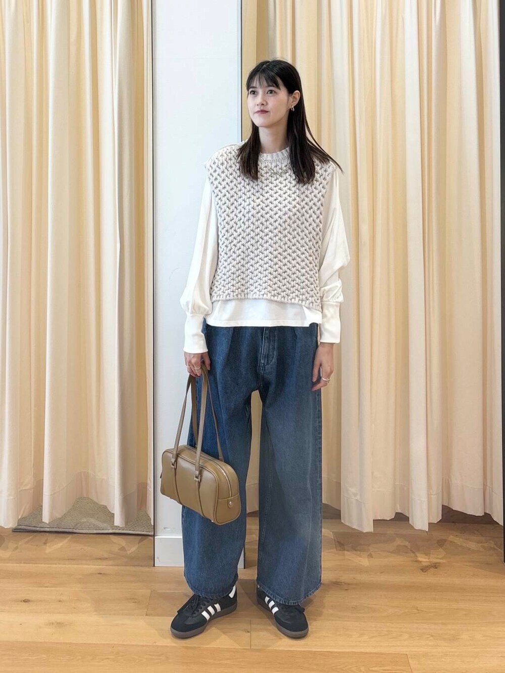 ホワイト系のTシャツ/カットソー、グリーン系のボストンバッグ、ブラック系のスニーカーを着用したレディースの秋コーディネートの2枚目の写真