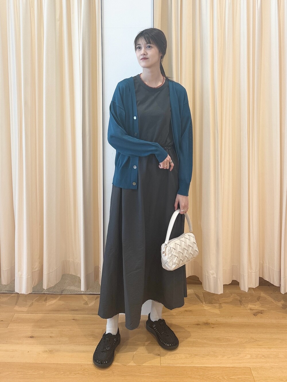 ホワイト系のショルダーバッグ、ブルー系のカーディガン/ボレロ、グレー系のワンピースを着用したレディースの夏コーディネートの5枚目の写真