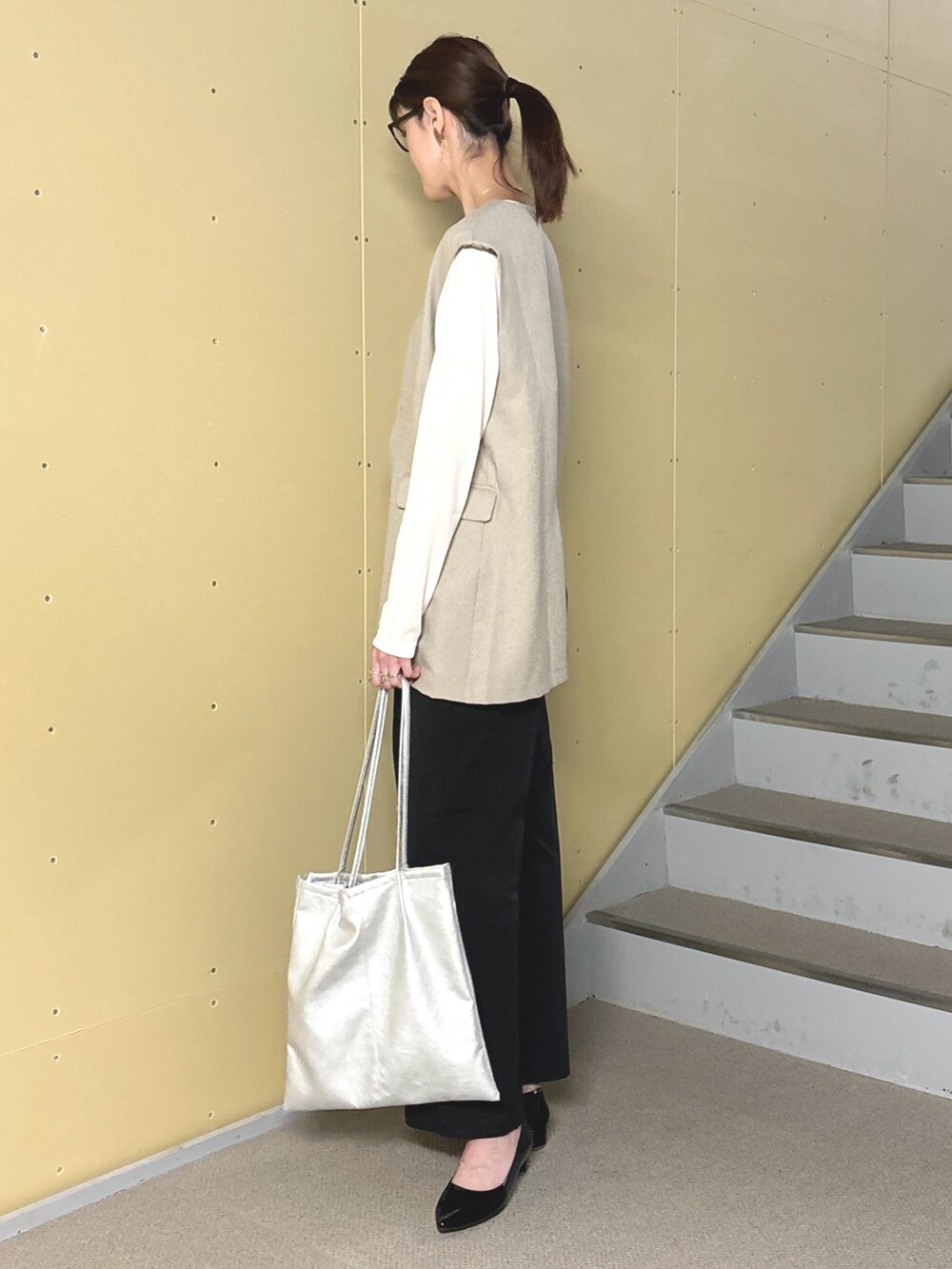 ブラック系のパンプス、シルバー系のトートバッグ、ホワイト系のTシャツ/カットソーを着用したレディースの春コーディネートの3枚目の写真