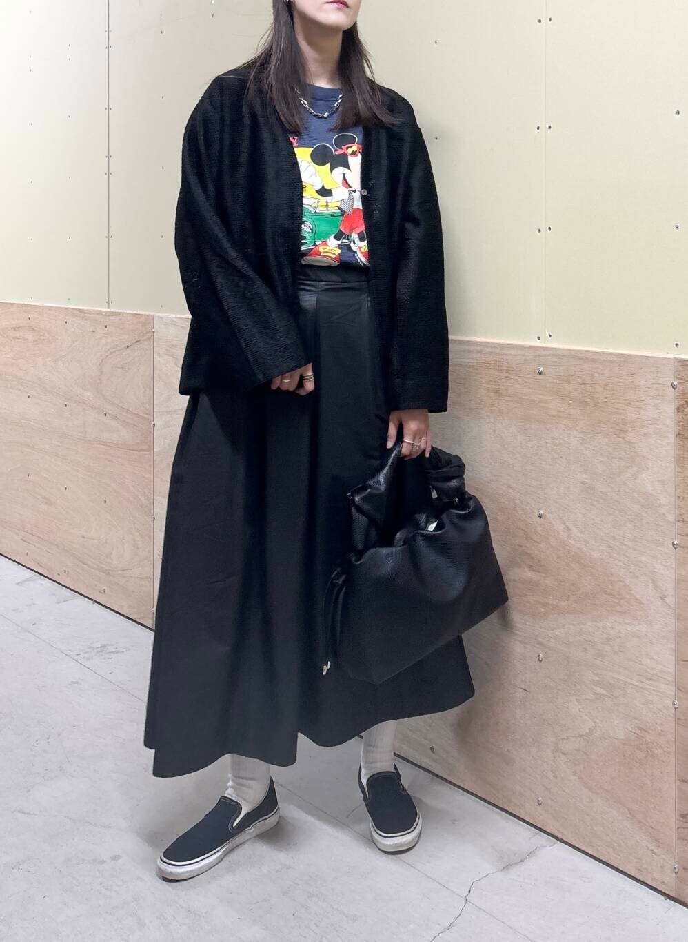 ブラック系のハンドバッグ、ブラック系のスカート、ブラック系のカーディガン/ボレロを着用したレディースの秋コーディネートの6枚目の写真