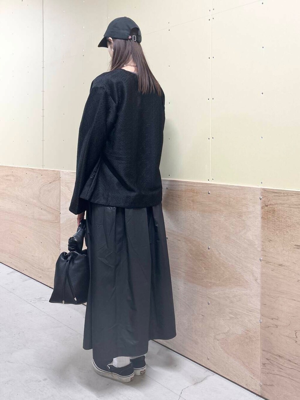 ブラック系のハンドバッグ、ブラック系のスカート、ブラック系のカーディガン/ボレロを着用したレディースの秋コーディネートの5枚目の写真