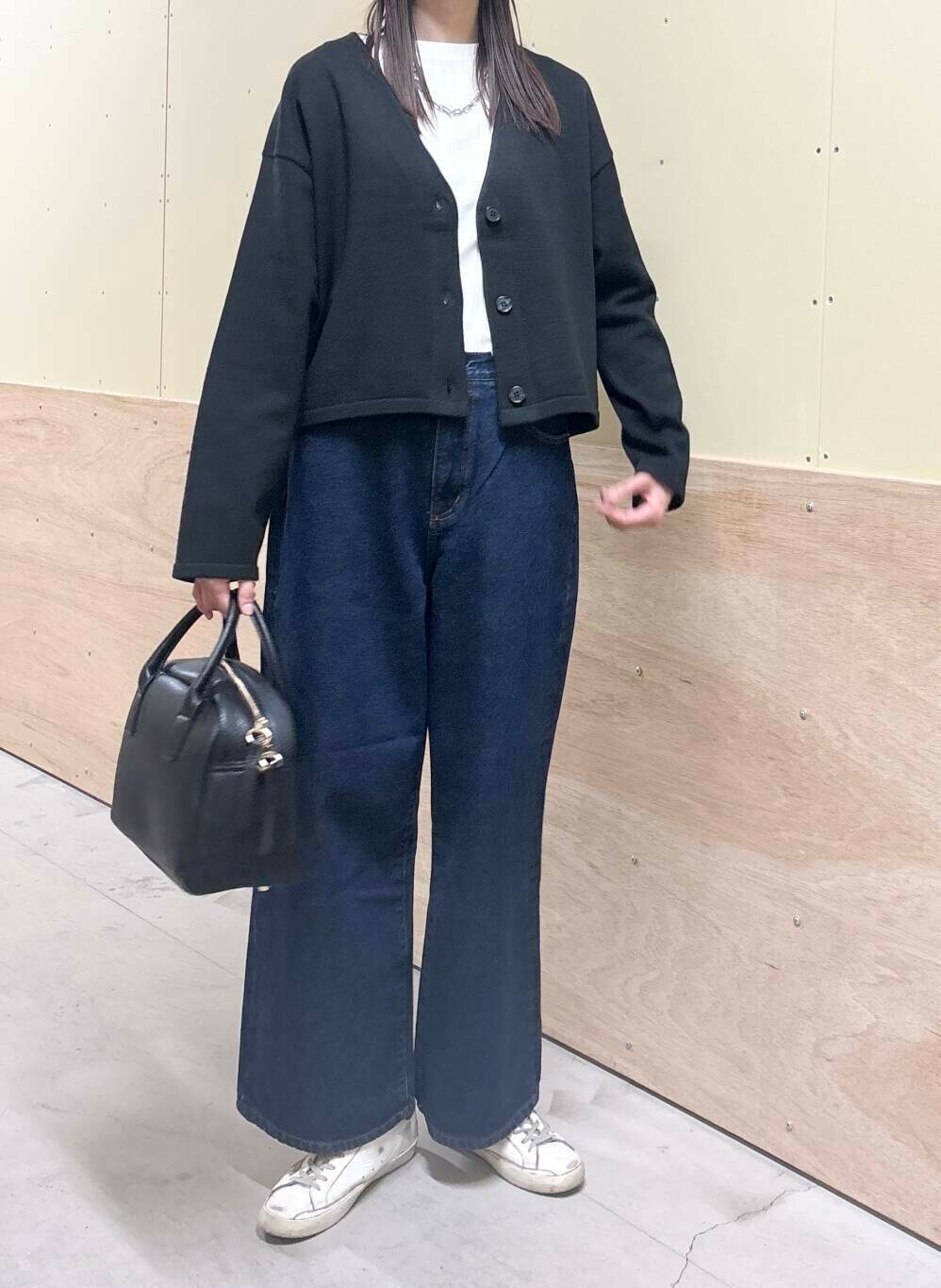 ブルー系のデニムパンツ、ホワイト系のTシャツ/カットソー、ブラック系のボストンバッグを着用したレディースの秋コーディネートの4枚目の写真