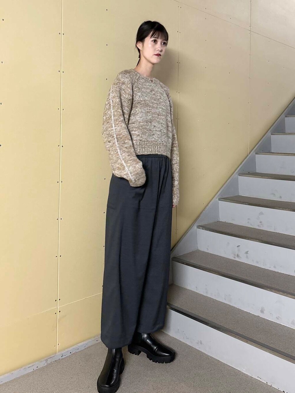 ブラック系のブーツ、ホワイト系のブルゾン、ベージュ系のニット/セーターを着用したレディースの冬コーディネートの5枚目の写真