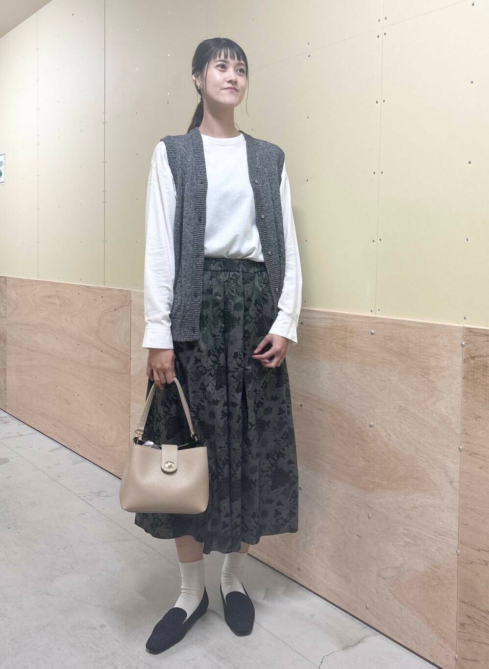 ベージュ系のショルダーバッグ、ブラック系のスカート、ブラック系のローファーを着用したレディースの秋コーディネートの4枚目の写真