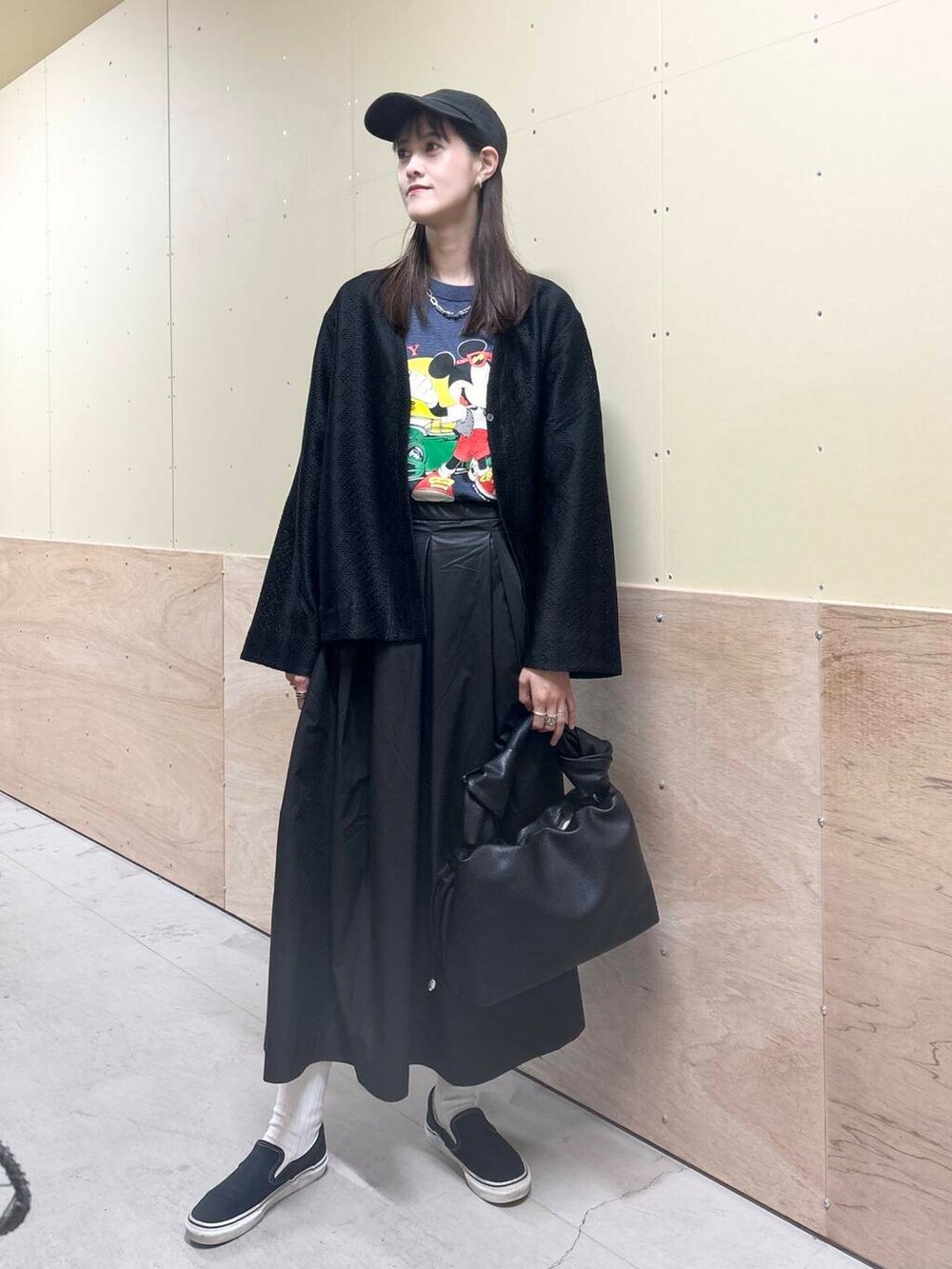 ブラック系のハンドバッグ、ブラック系のスカート、ブラック系のカーディガン/ボレロを着用したレディースの秋コーディネートの3枚目の写真