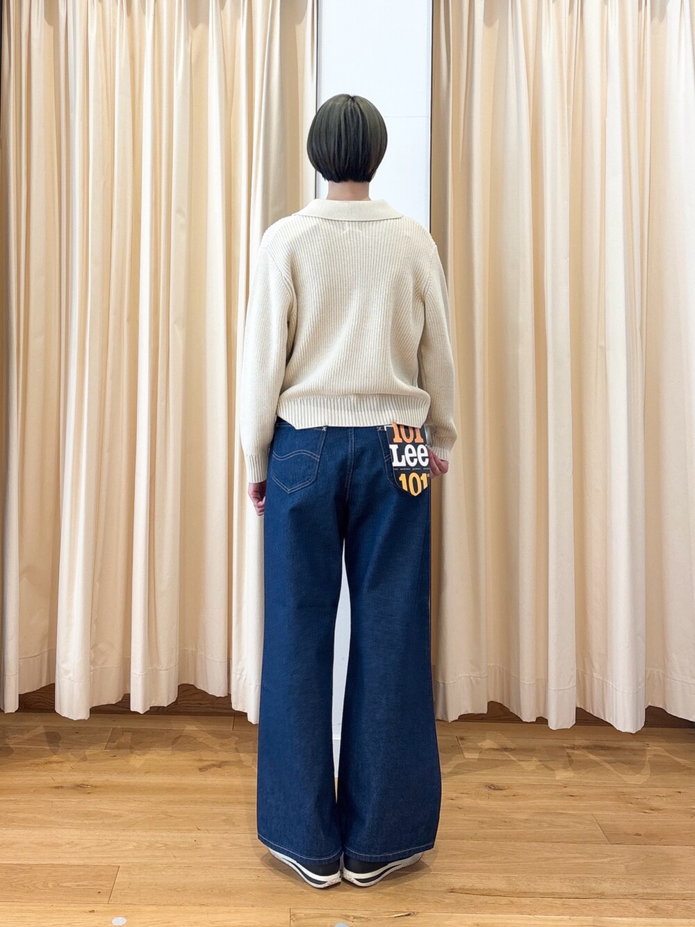ホワイト系のニット/セーター、ブルー系のデニムパンツを着用したレディースの冬コーディネートの4枚目の写真
