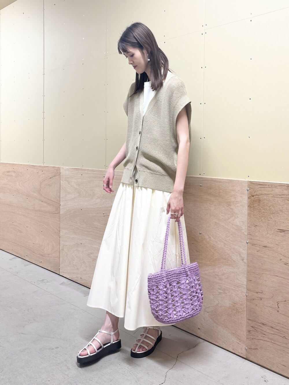 ベージュ系のベスト、ホワイト系のスカート、シルバー系のサンダルを着用したレディースの夏コーディネートの2枚目の写真