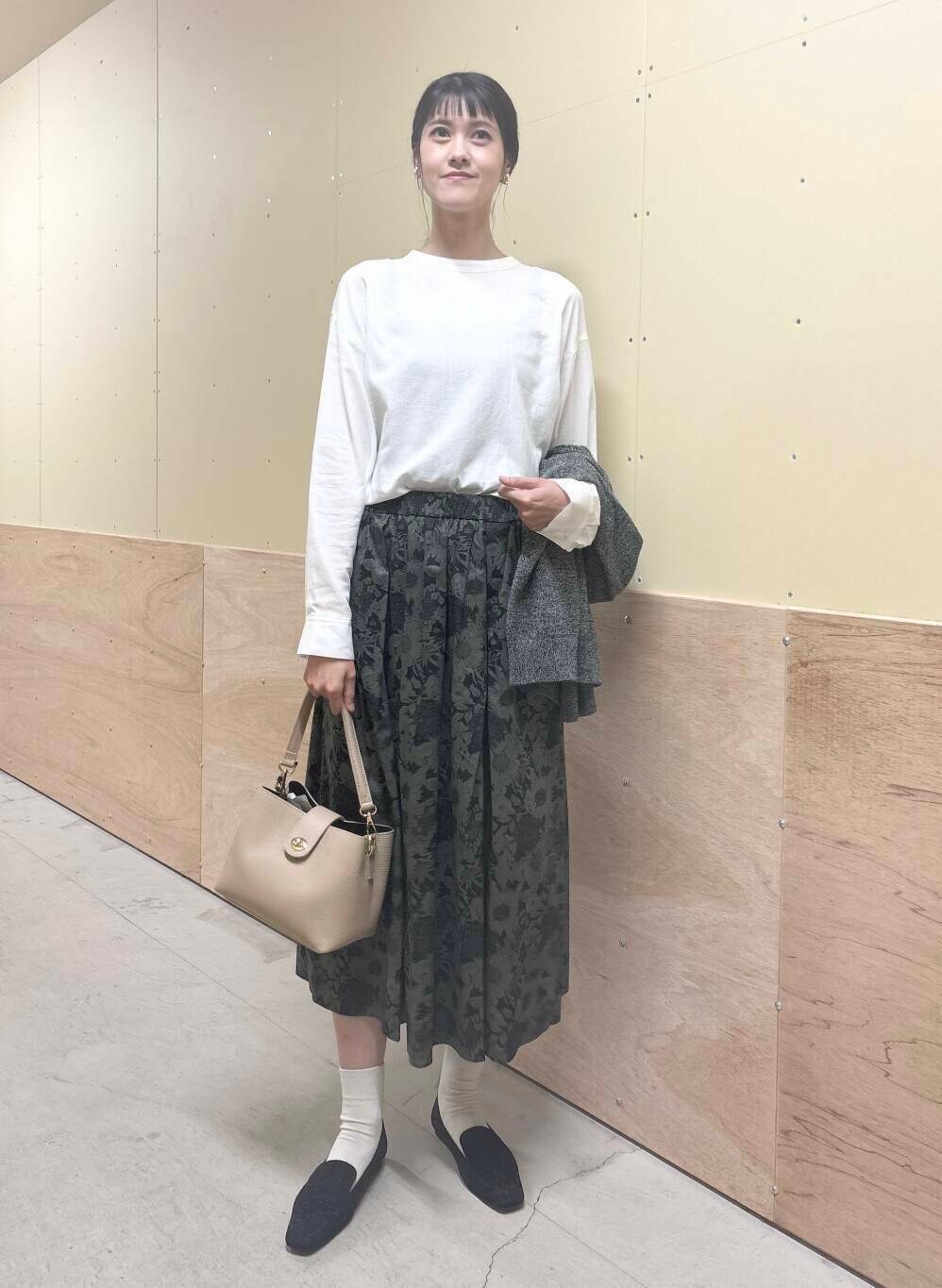 ベージュ系のショルダーバッグ、ブラック系のスカート、ブラック系のローファーを着用したレディースの秋コーディネートの6枚目の写真