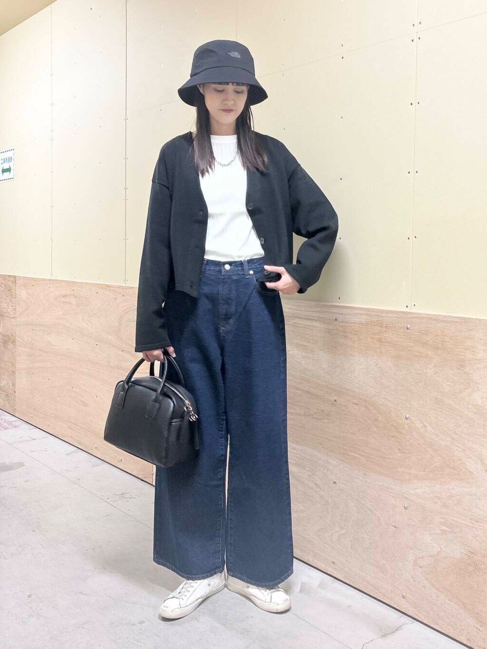 ブルー系のデニムパンツ、ホワイト系のTシャツ/カットソー、ブラック系のボストンバッグを着用したレディースの秋コーディネートの2枚目の写真