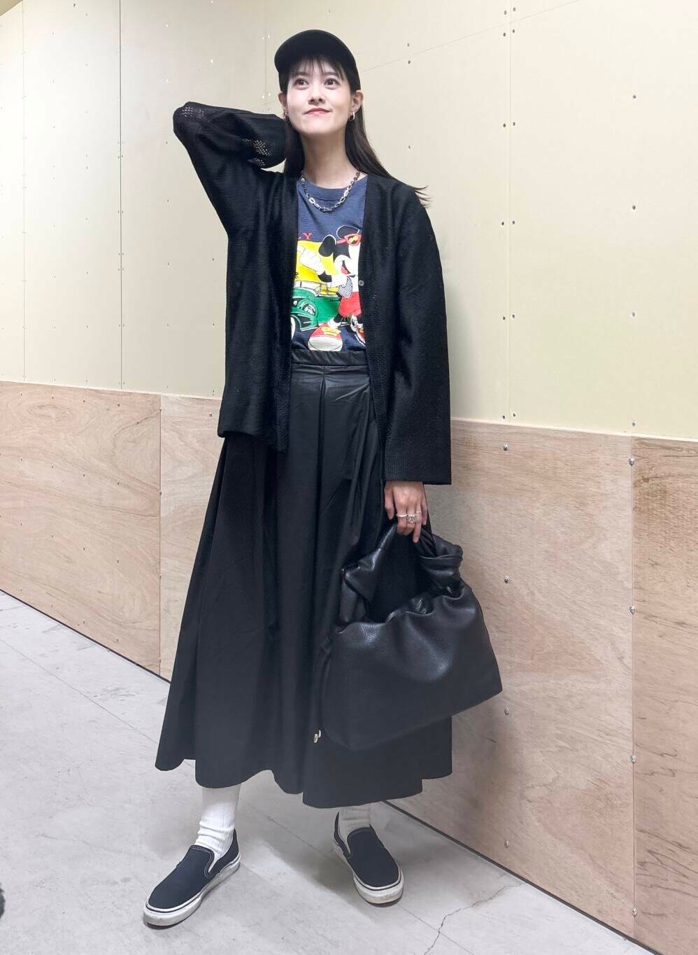 ブラック系のハンドバッグ、ブラック系のスカート、ブラック系のカーディガン/ボレロを着用したレディースの秋コーディネートの2枚目の写真