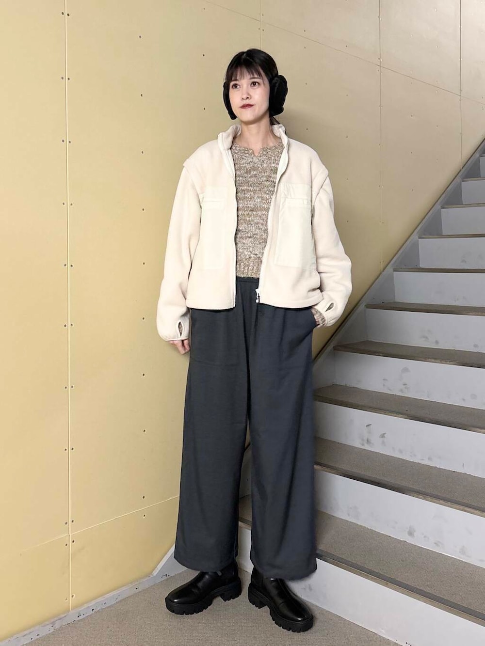 ブラック系のブーツ、ホワイト系のブルゾン、ベージュ系のニット/セーターを着用したレディースの冬コーディネートの2枚目の写真