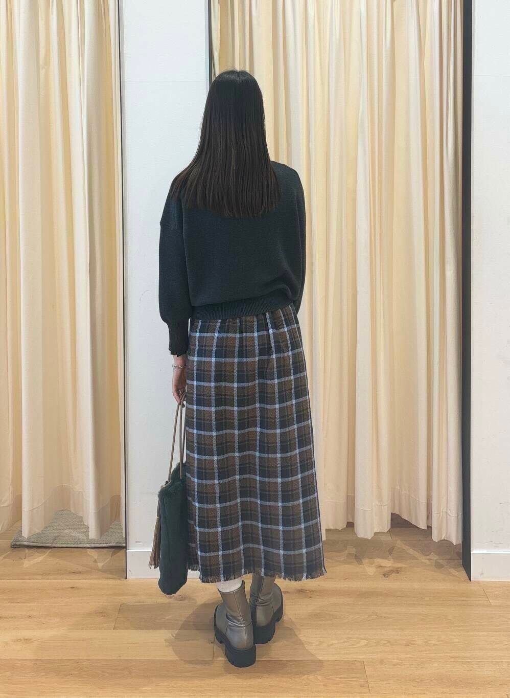 グレー系のニット/セーター、シルバー系のブーツ、ブラウン系のスカートを着用したレディースの秋コーディネートの5枚目の写真
