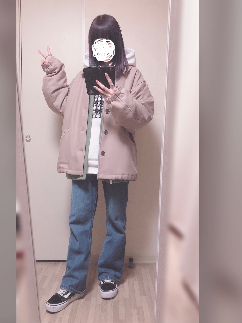 ホワイト系のパーカー、グリーン系のカーディガン/ボレロ、ブルー系のデニムパンツを着用したレディースの冬コーディネートの2枚目の写真