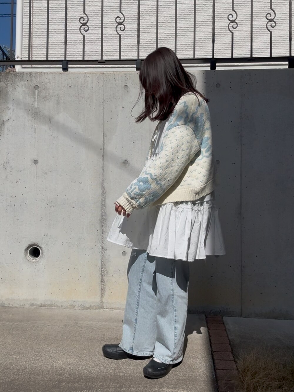 ブルー系のデニムパンツ、ブルー系のキャミソール、ブラック系のスニーカーを着用したレディースの春コーディネートの2枚目の写真