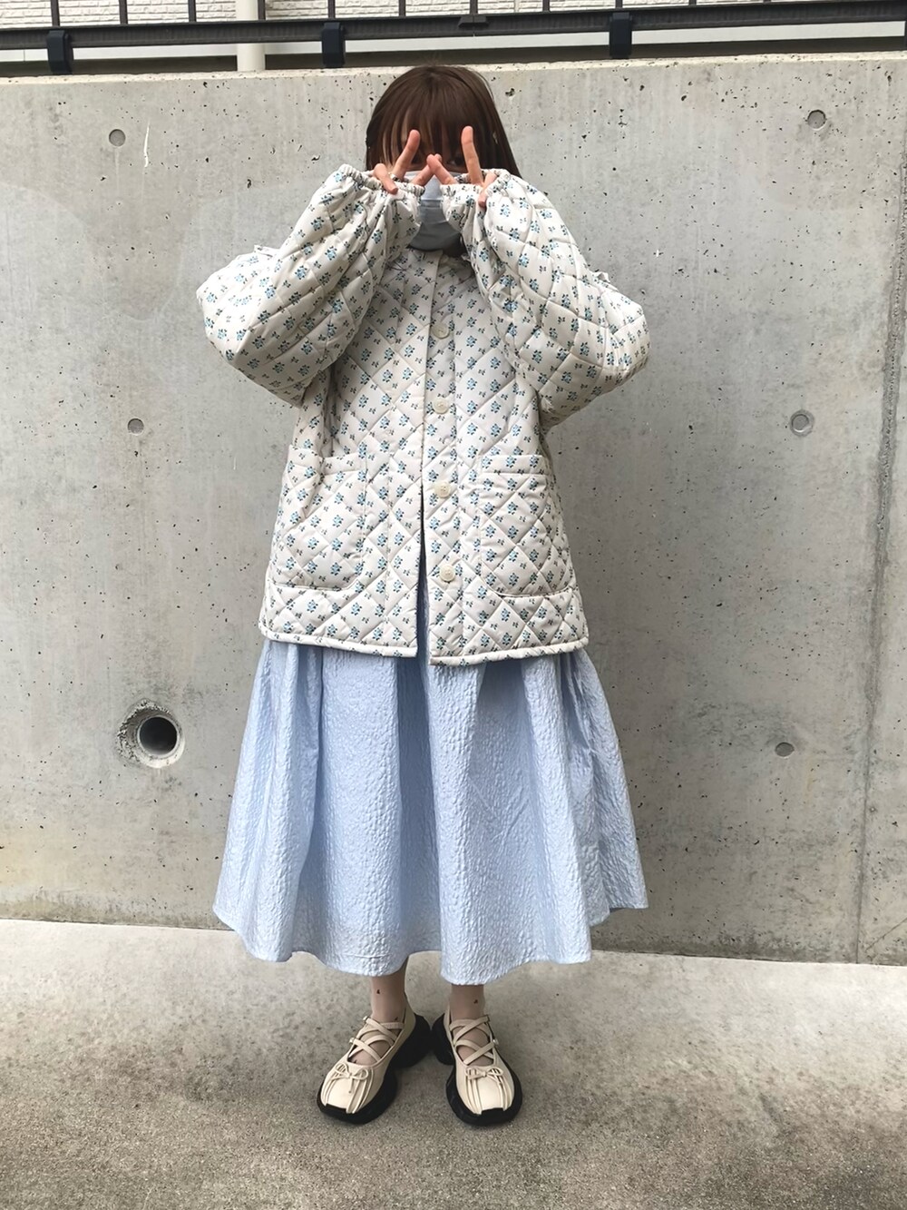 ホワイト系のダウンジャケット/コート、ブルー系のワンピースを着用したレディースの冬コーディネートの3枚目の写真