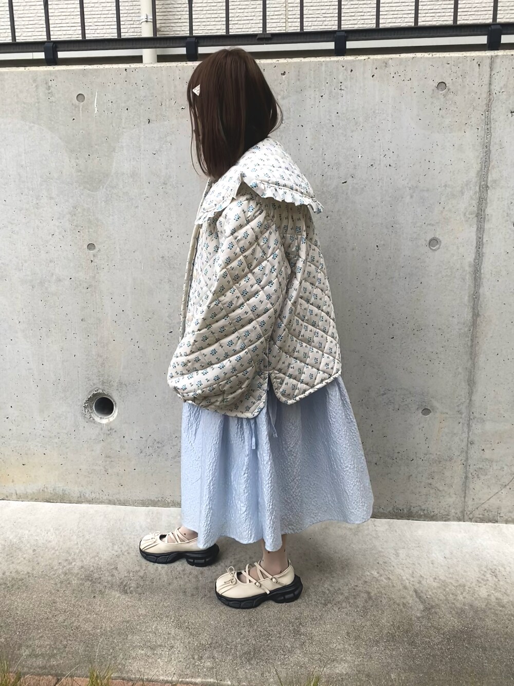 ホワイト系のダウンジャケット/コート、ブルー系のワンピースを着用したレディースの冬コーディネートの2枚目の写真