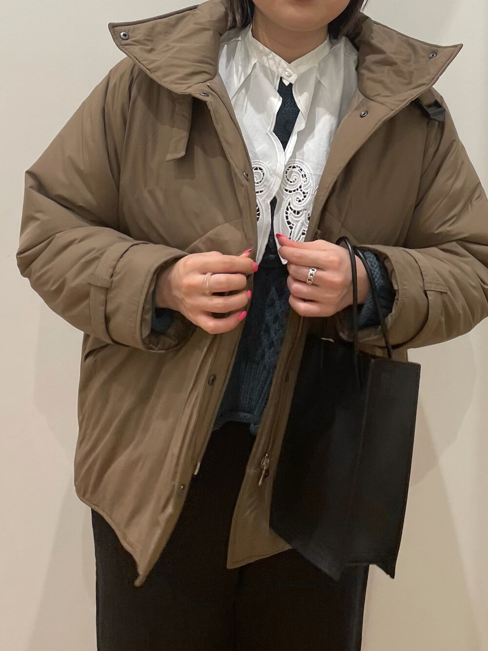 ベージュ系のダウンジャケット/コート、ホワイト系のシャツ/ブラウス、ブルー系のニット/セーターを着用したレディースの秋コーディネートの4枚目の写真