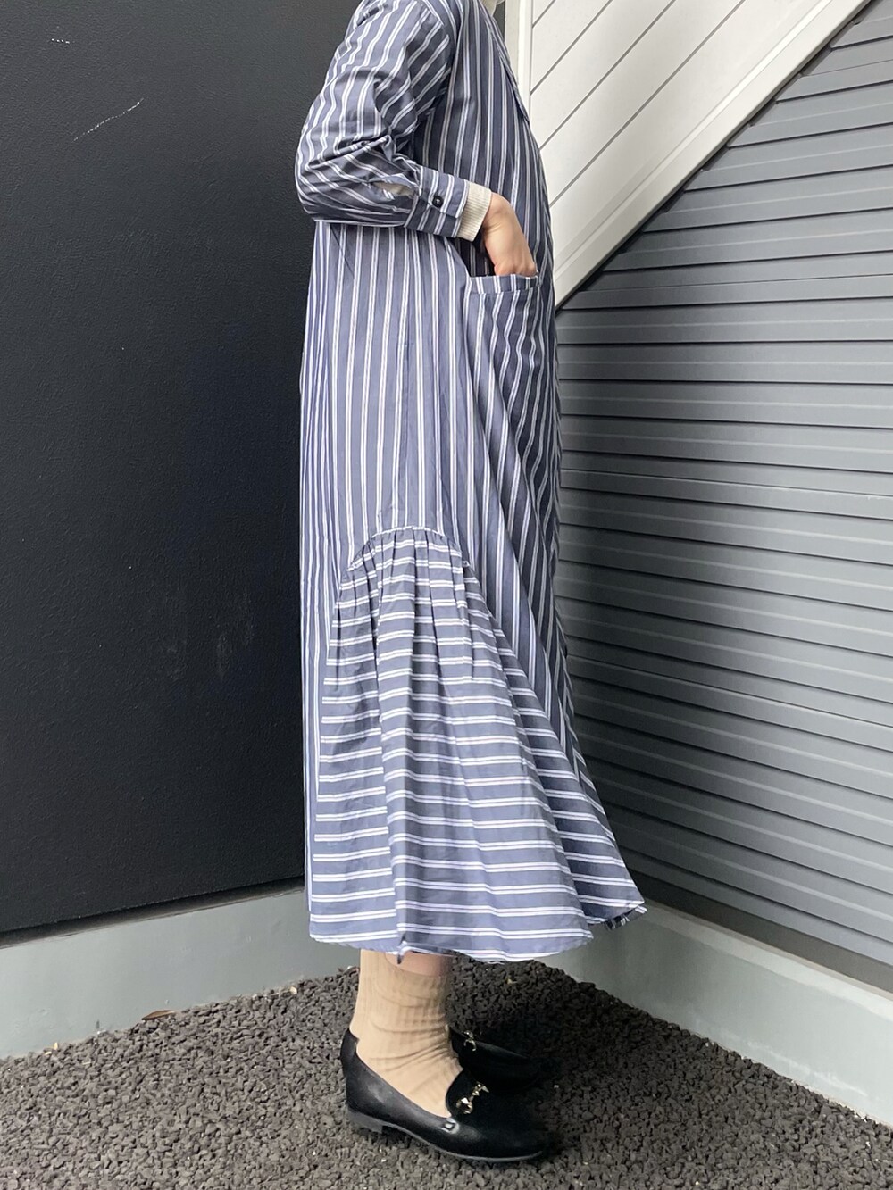 ブラック系のローファー、ブラック系のショルダーバッグ、ブルー系のワンピースを着用したレディースの冬コーディネートの2枚目の写真