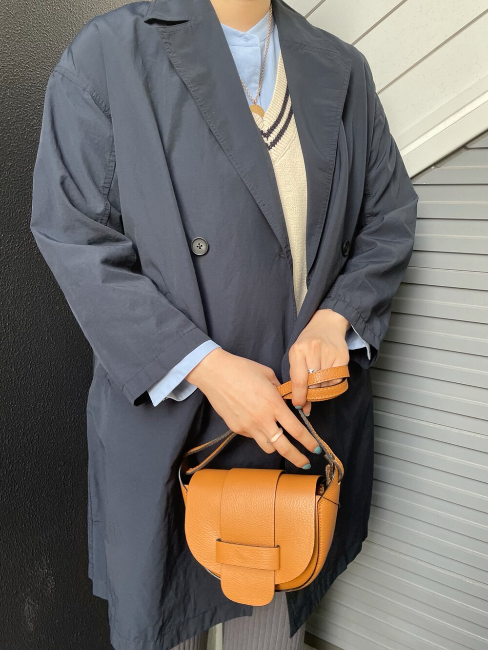 ベージュ系のショルダーバッグ、グレー系のパンツ、ブラック系のローファーを着用したレディースの冬コーディネートの2枚目の写真