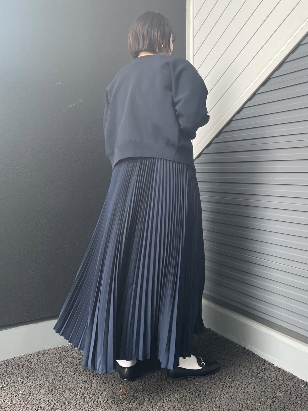 グリーン系のトートバッグ、ブルー系のスカート、ブラック系のローファーを着用したレディースの冬コーディネートの3枚目の写真