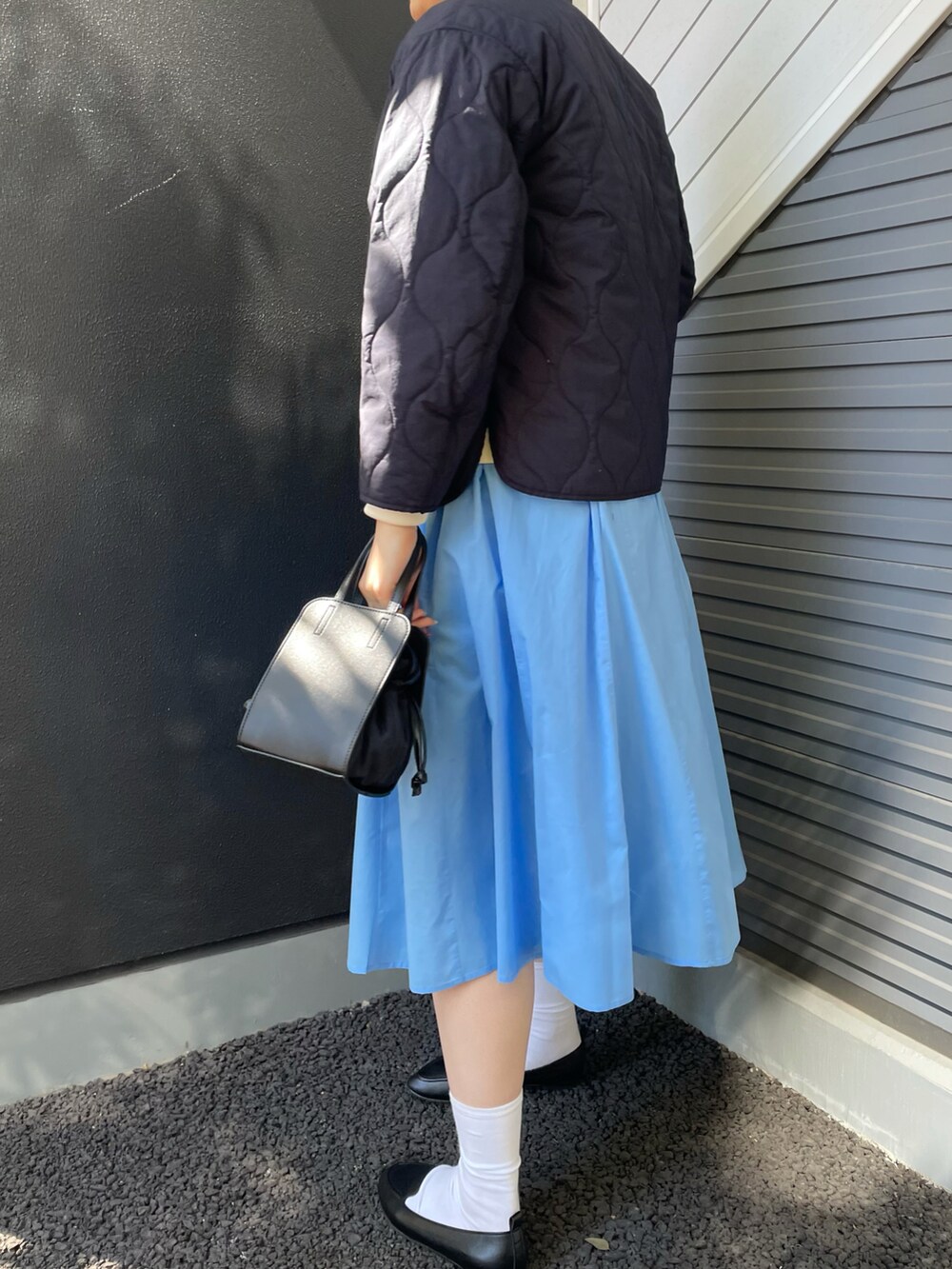 ブルー系のダウンジャケット/コート、ブルー系のワンピース、ホワイト系のスウェットを着用したレディースの冬コーディネートの2枚目の写真