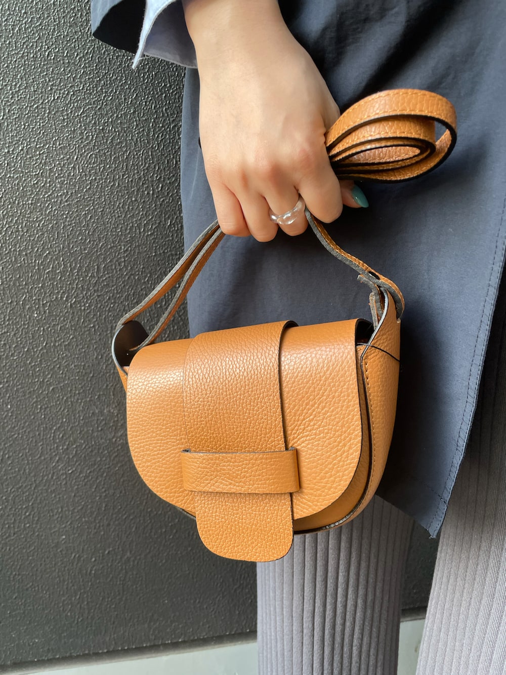 ベージュ系のショルダーバッグ、グレー系のパンツ、ブラック系のローファーを着用したレディースの冬コーディネートの3枚目の写真