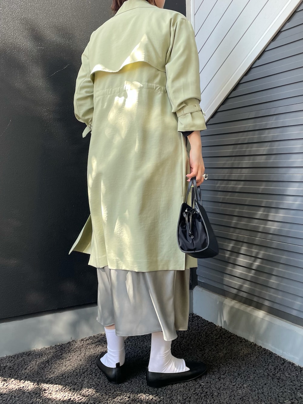 ブラック系のショルダーバッグ、ブラック系のスリッポン、グレー系のスカートを着用したレディースの冬コーディネートの2枚目の写真