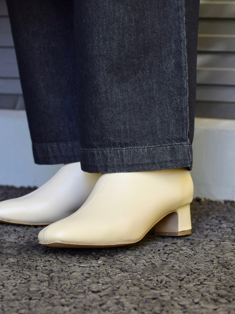 グレー系のチェスターコート、ベージュ系のワンピース、ホワイト系のトートバッグを着用したレディースの秋コーディネートの3枚目の写真