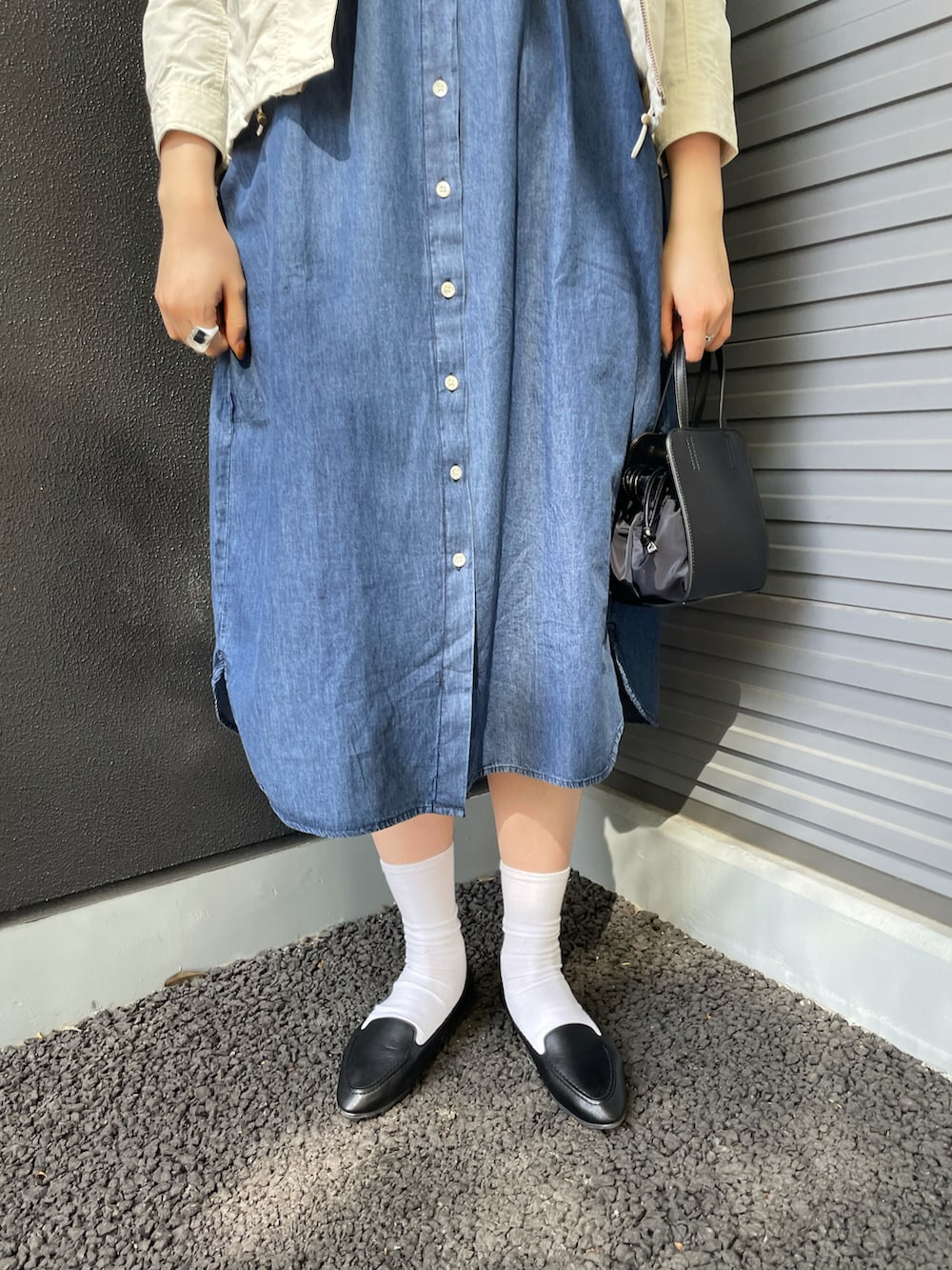 ブルー系のワンピース/ドレス、ホワイト系のマウンテンパーカー、ブラック系のショルダーバッグを着用したレディースの春コーディネートの3枚目の写真