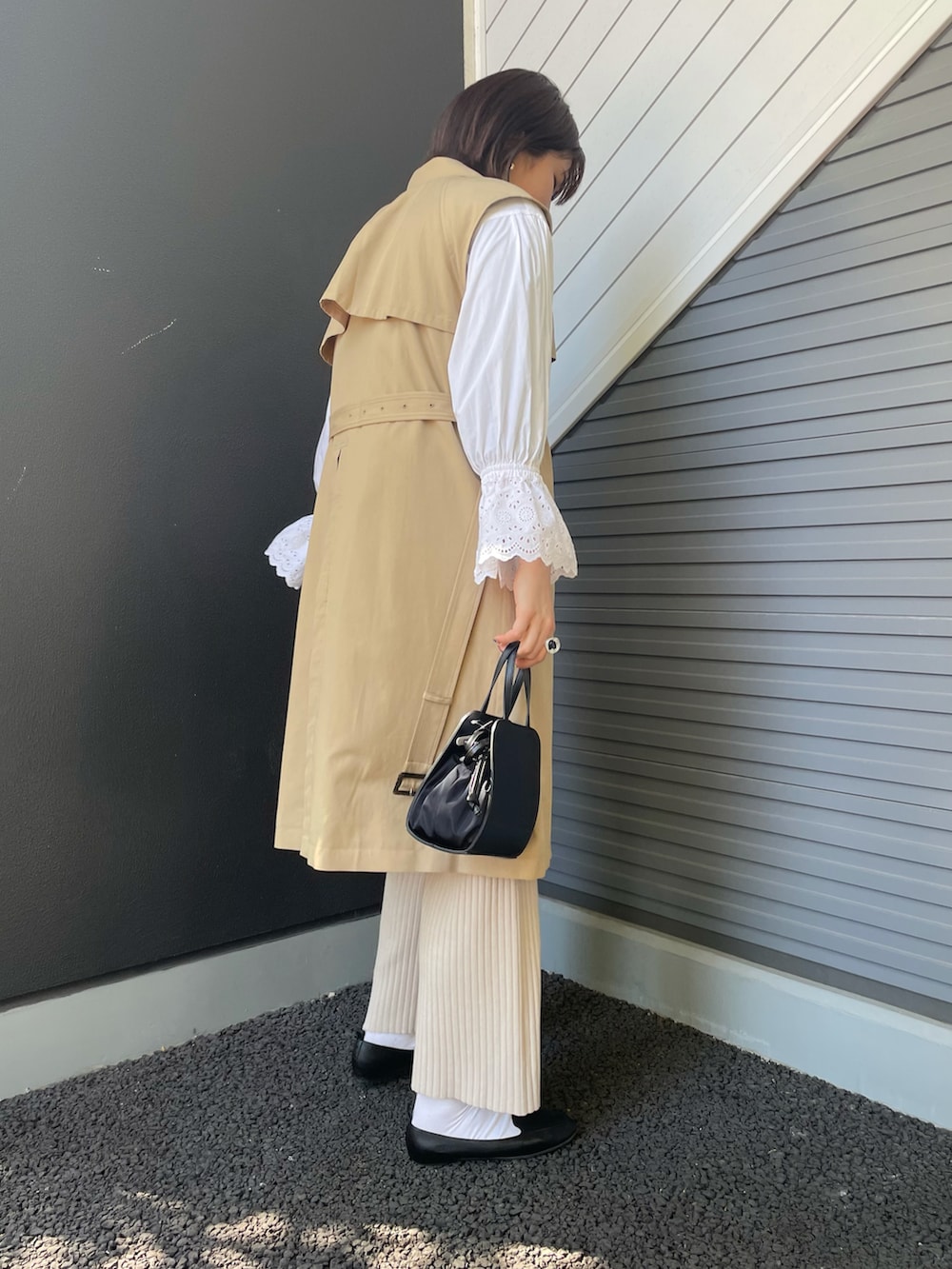 ベージュ系のベスト、ホワイト系のシャツ/ブラウス、ブラック系のショルダーバッグを着用したレディースの冬コーディネートの2枚目の写真