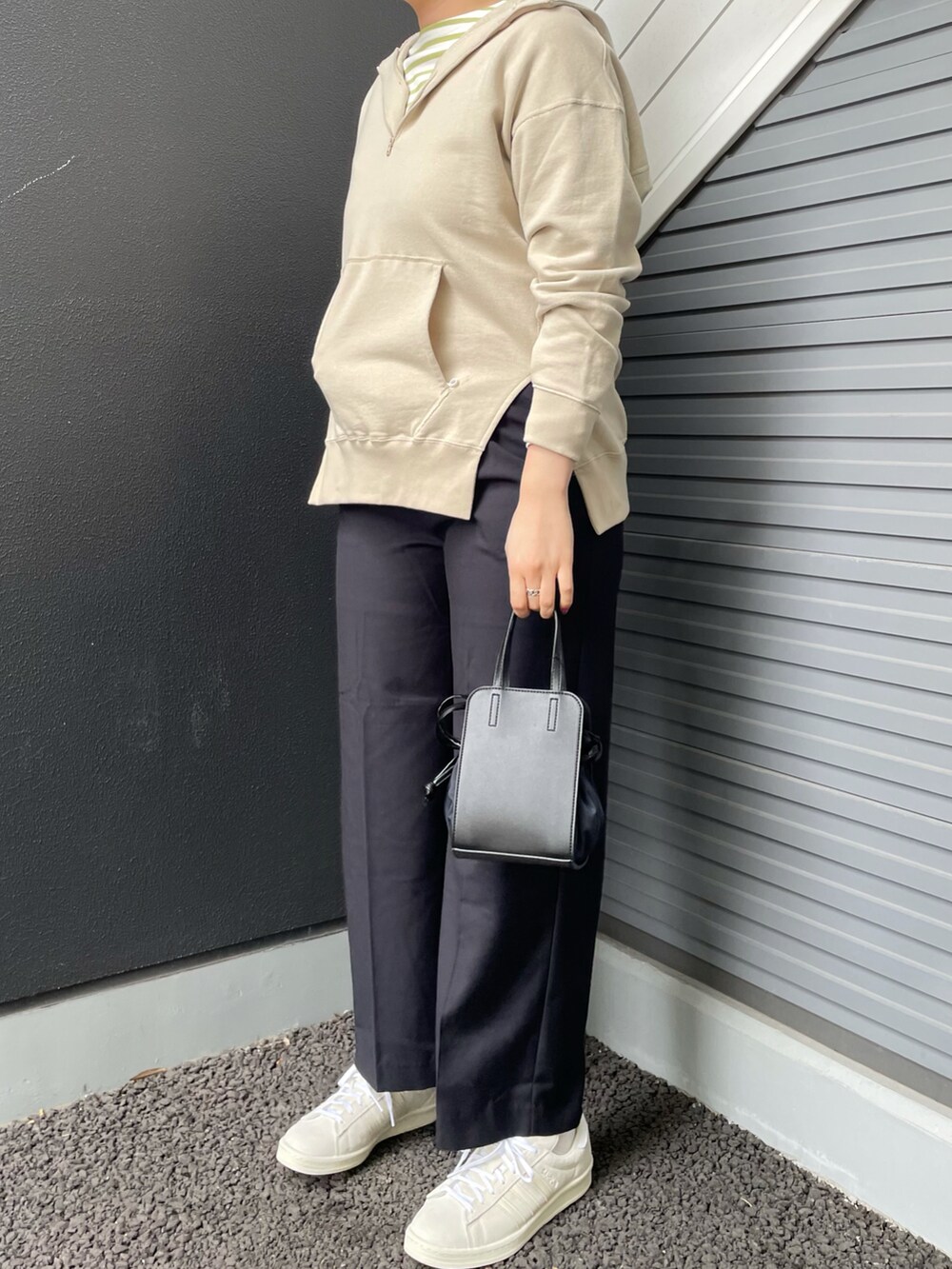 ベージュ系のパーカー、グリーン系のTシャツ/カットソー、ブラック系のショルダーバッグを着用したレディースの冬コーディネートの2枚目の写真