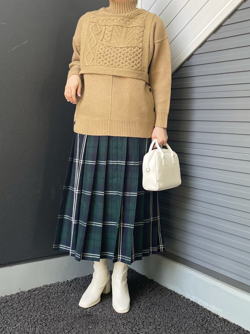 ベージュ系のベスト、ベージュ系のニット/セーター、ブルー系のスカートを着用したレディースの冬コーディネートの2枚目の写真