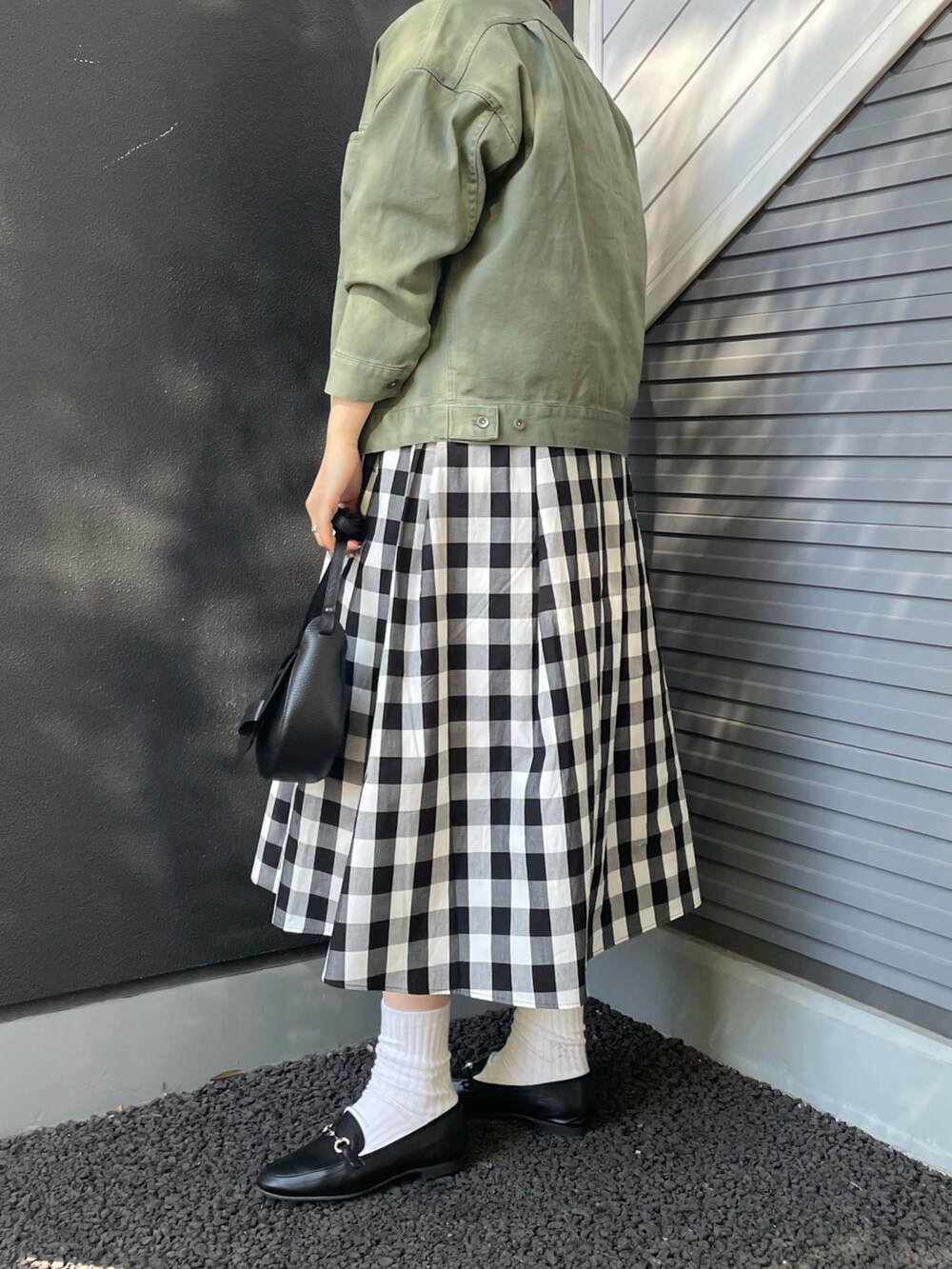 ブラック系のショルダーバッグ、ブラック系のローファー、その他のスカートを着用したレディースの冬コーディネートの3枚目の写真