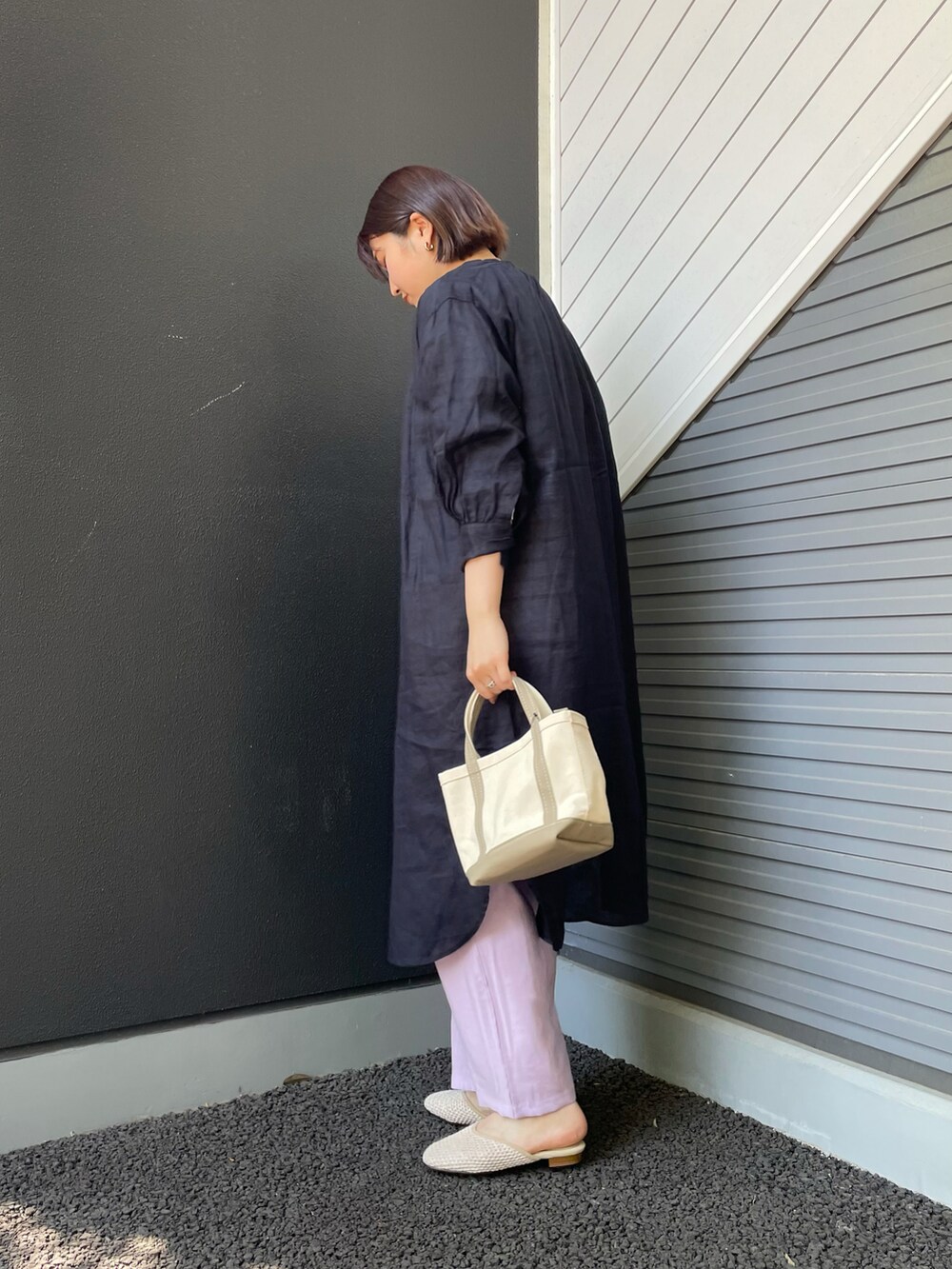 ブルー系のワンピース、ベージュ系のハンドバッグ、ブルー系のTシャツ/カットソーを着用したレディースの春コーディネートの2枚目の写真