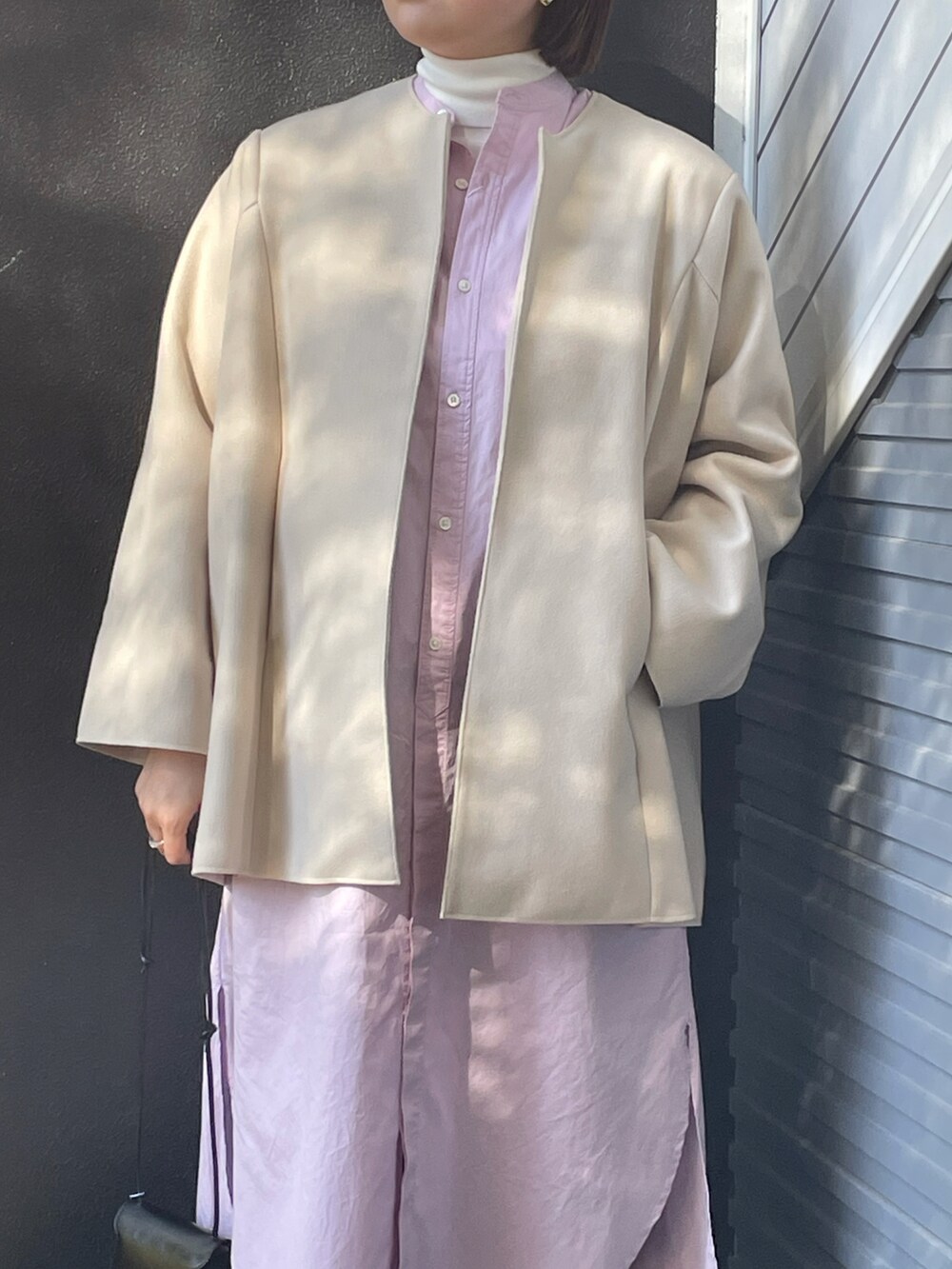 ホワイト系のジャケット/アウター、ブラック系のショルダーバッグ、ピンク系のワンピースを着用したレディースの冬コーディネートの2枚目の写真