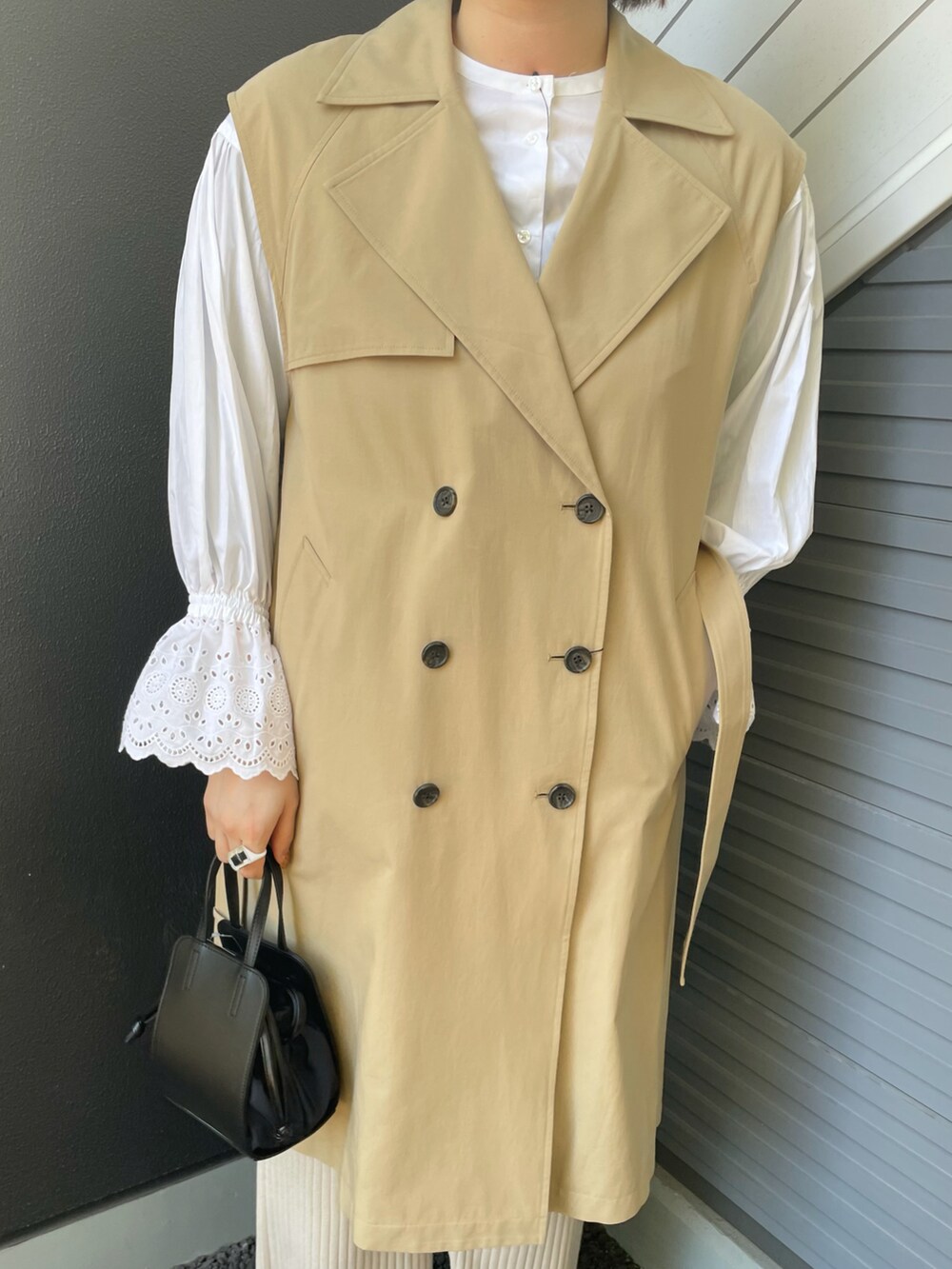 ベージュ系のベスト、ホワイト系のシャツ/ブラウス、ブラック系のショルダーバッグを着用したレディースの冬コーディネートの3枚目の写真