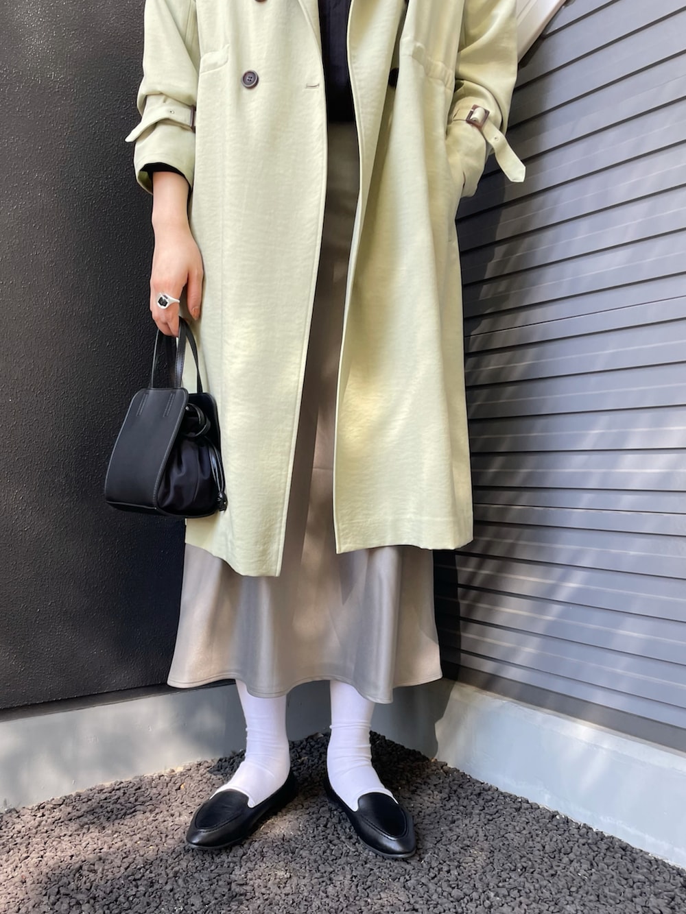 ブラック系のショルダーバッグ、ブラック系のスリッポン、グレー系のスカートを着用したレディースの冬コーディネートの3枚目の写真