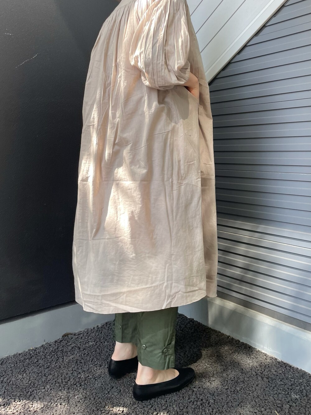 グレー系のワンピース、ブルー系のハンドバッグ、ブラック系のパンプスを着用したレディースの春コーディネートの3枚目の写真