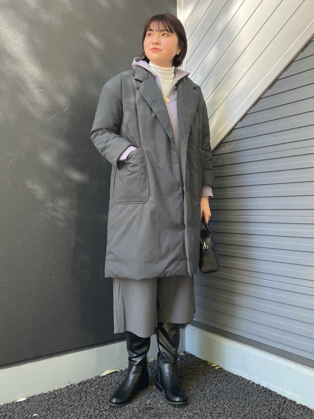 パープル系のパーカー、ホワイト系のTシャツ/カットソー、ブラック系のボストンバッグを着用したレディースの冬コーディネートの2枚目の写真