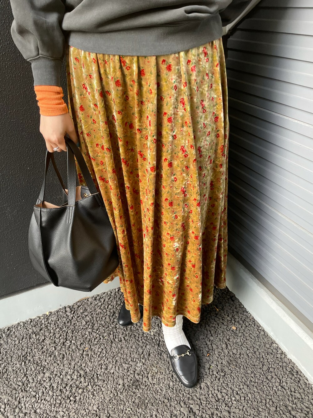 グレー系のスウェット、オレンジ系のTシャツ/カットソー、ブラック系のトートバッグを着用したレディースの冬コーディネートの3枚目の写真