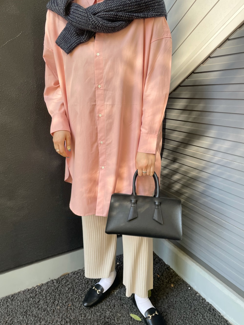 ピンク系のシャツ/ブラウス、ブルー系のニット/セーター、ブラック系のバッグを着用したレディースの冬コーディネートの3枚目の写真