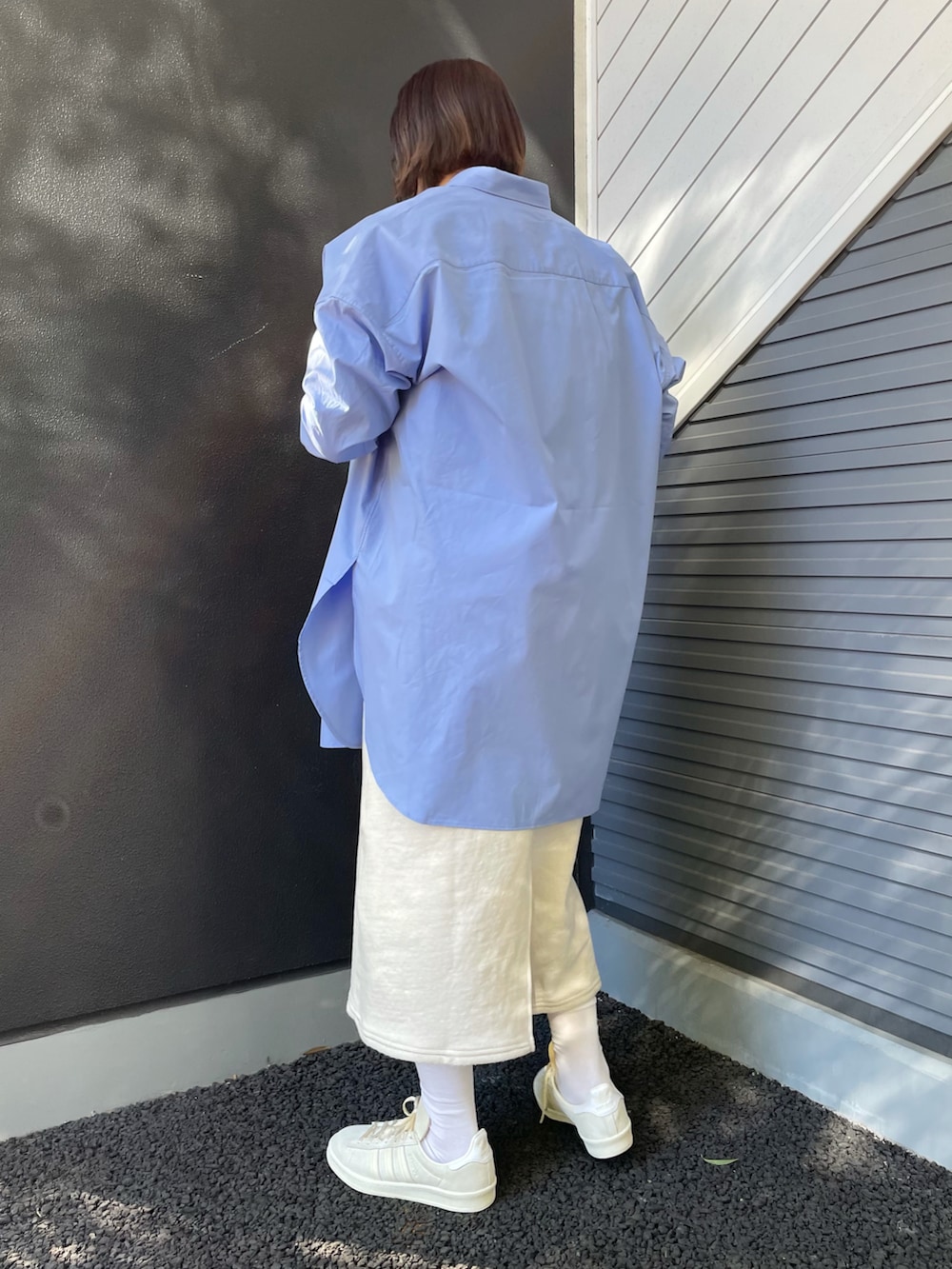 ベージュ系のショルダーバッグ、ブルー系のシャツ/ブラウス、グリーン系のニット/セーターを着用したレディースの冬コーディネートの2枚目の写真