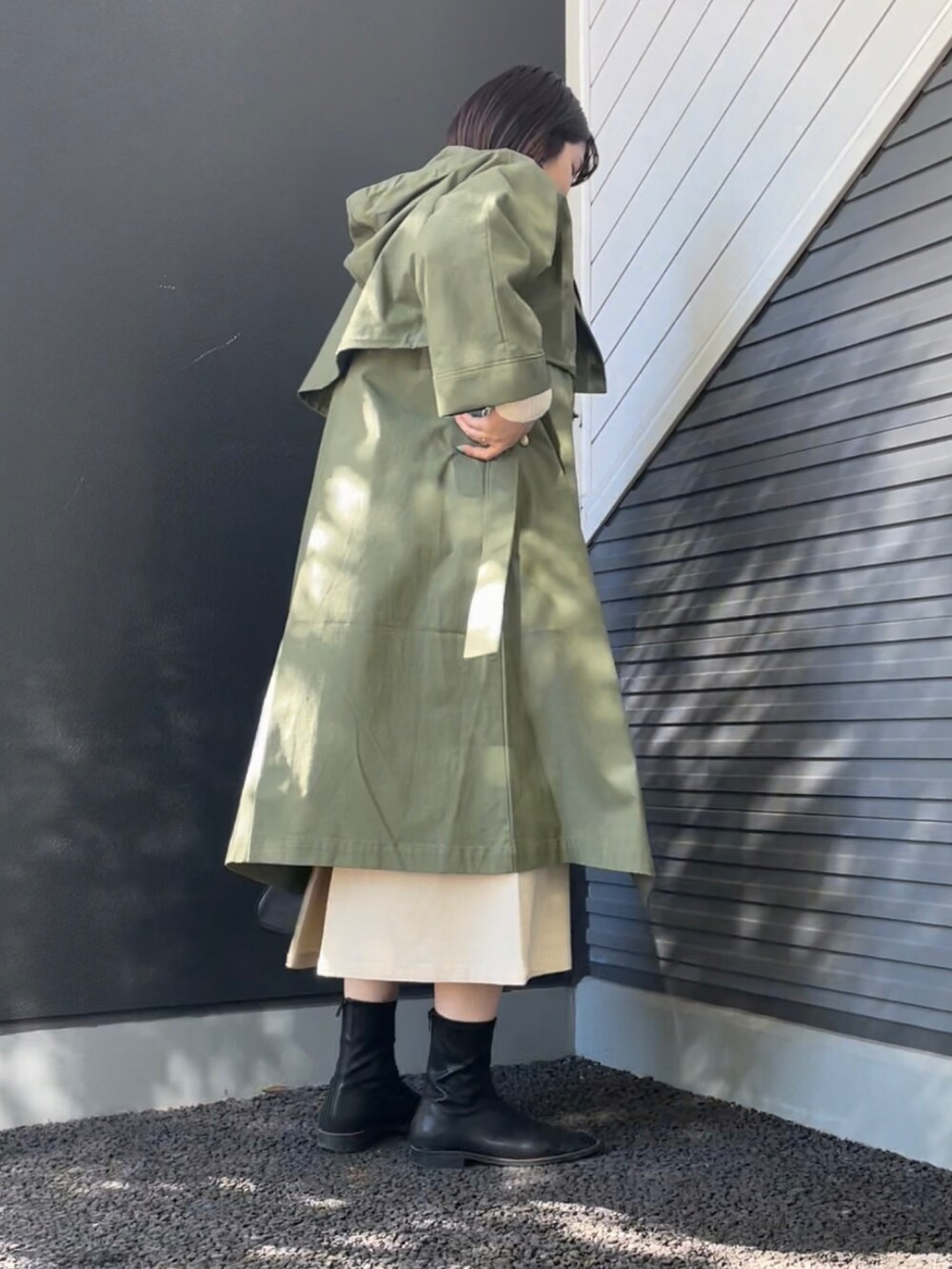 グリーン系のその他アウター、ホワイト系のニット/セーター、ベージュ系のスカートを着用したレディースの冬コーディネートの2枚目の写真