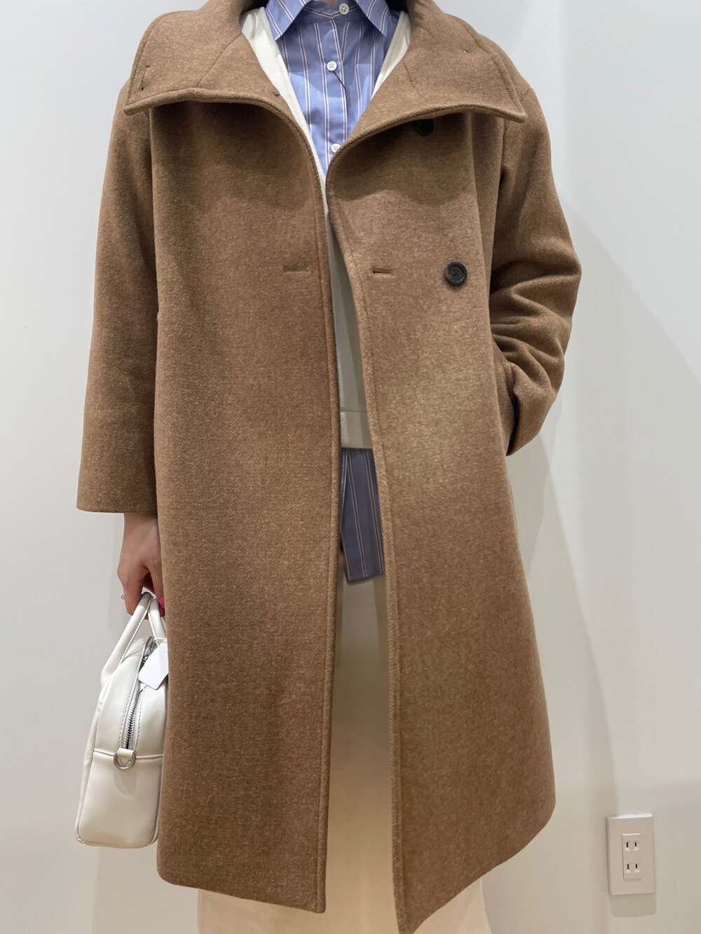 ベージュ系のその他アウター、ホワイト系のスカート、ホワイト系のボストンバッグを着用したレディースの秋コーディネートの3枚目の写真