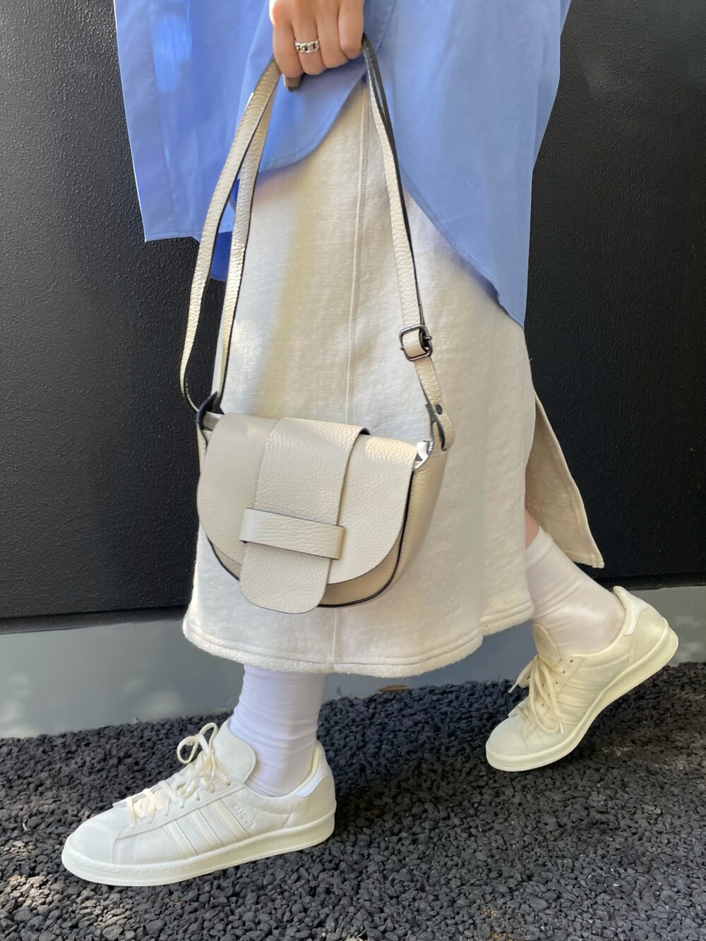 ベージュ系のショルダーバッグ、ブルー系のシャツ/ブラウス、グリーン系のニット/セーターを着用したレディースの冬コーディネートの4枚目の写真