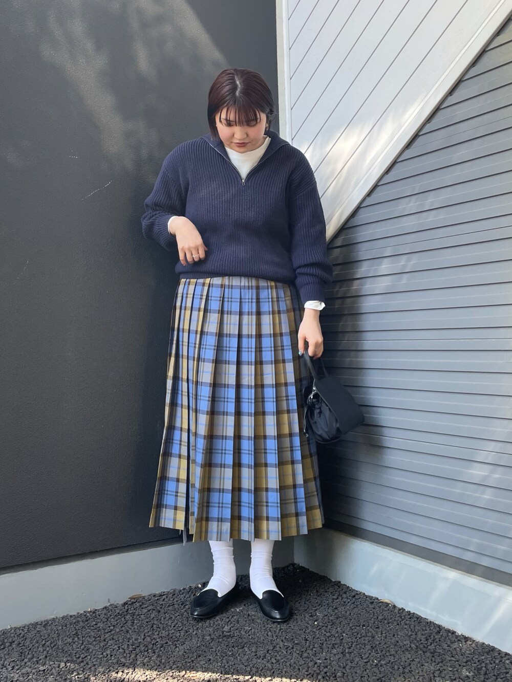 ブルー系のニット/セーター、ブルー系のスカート、ブラック系のショルダーバッグを着用したレディースの冬コーディネートの2枚目の写真