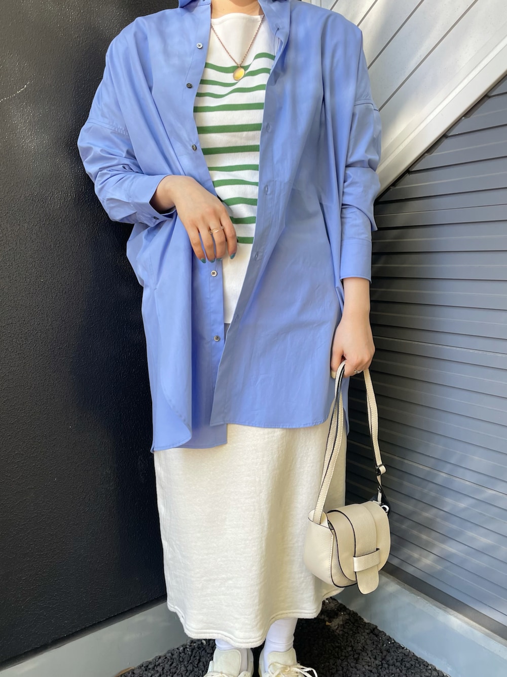 ベージュ系のショルダーバッグ、ブルー系のシャツ/ブラウス、グリーン系のニット/セーターを着用したレディースの冬コーディネートの3枚目の写真