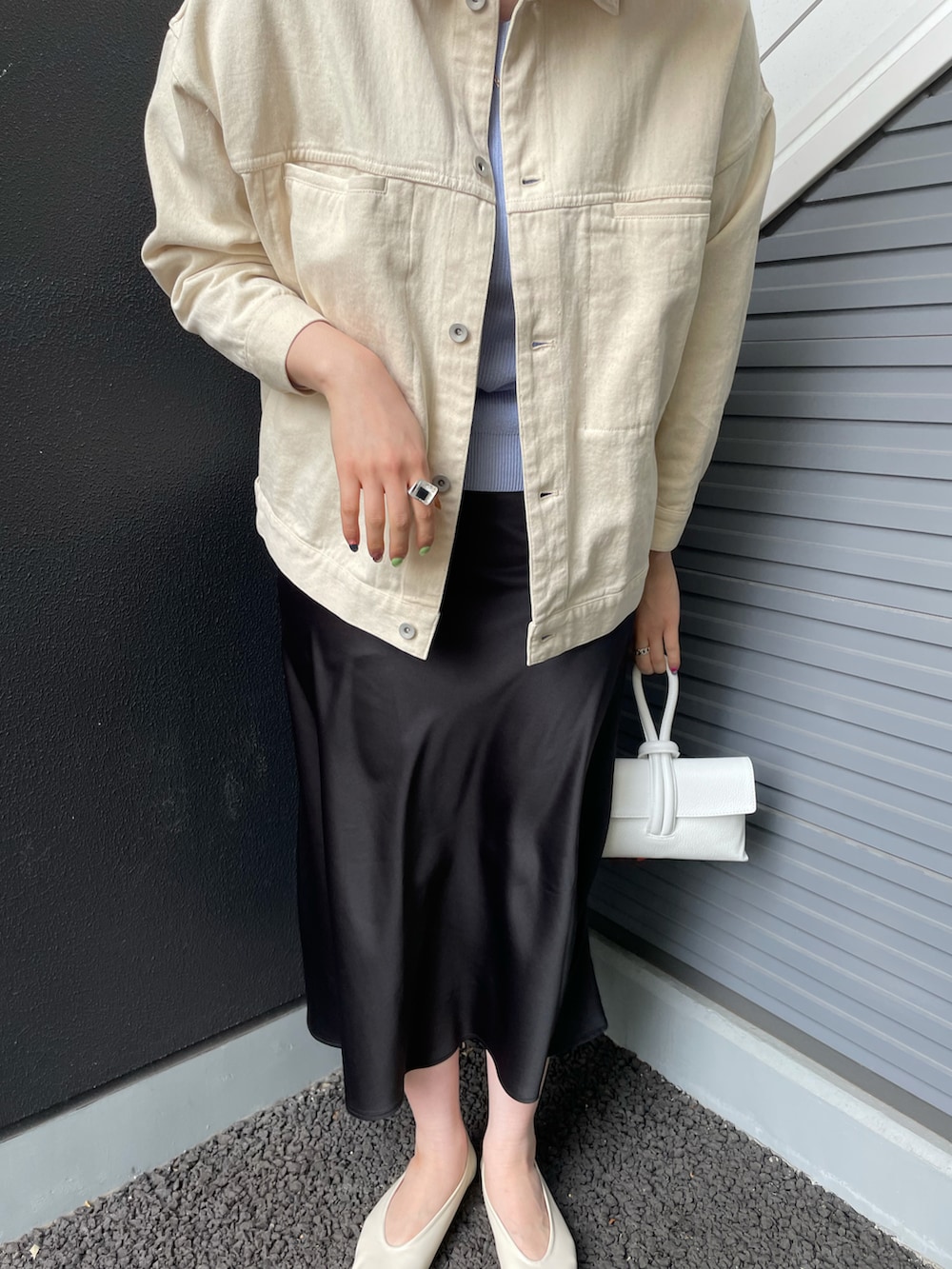 ブルー系のニット/セーター、ベージュ系のパンプス、ブラック系のスカートを着用したレディースの春コーディネートの2枚目の写真